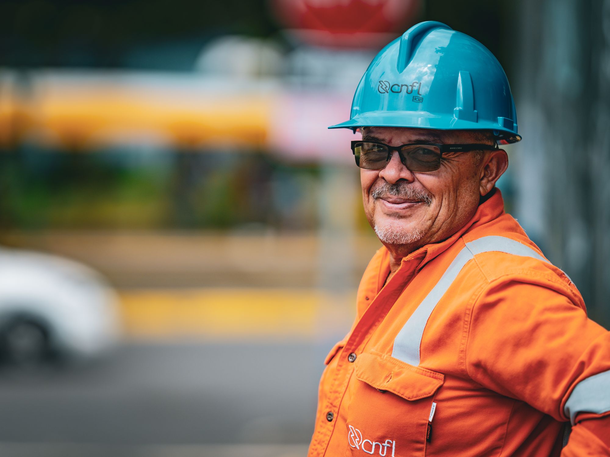Trabajador de la construcción sonriendo con casco y chaleco de seguridad